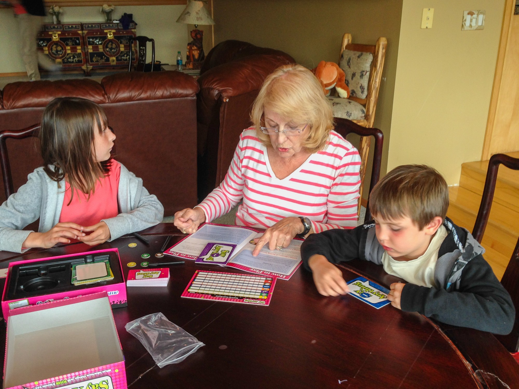 Grandma and kids playing board game together on family reunion vacation